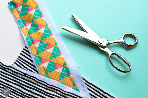 pinking shears with scrap fabric to make popsicle holder