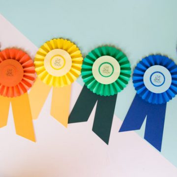 Use your Cricut to create these easy prize ribbons. Attach a gift card or use them as a fun embellishment to a gift bag. These prize ribbons were so easy to make with my Cricut. #CricutMade #RainbowCraft #PrizeRibbon