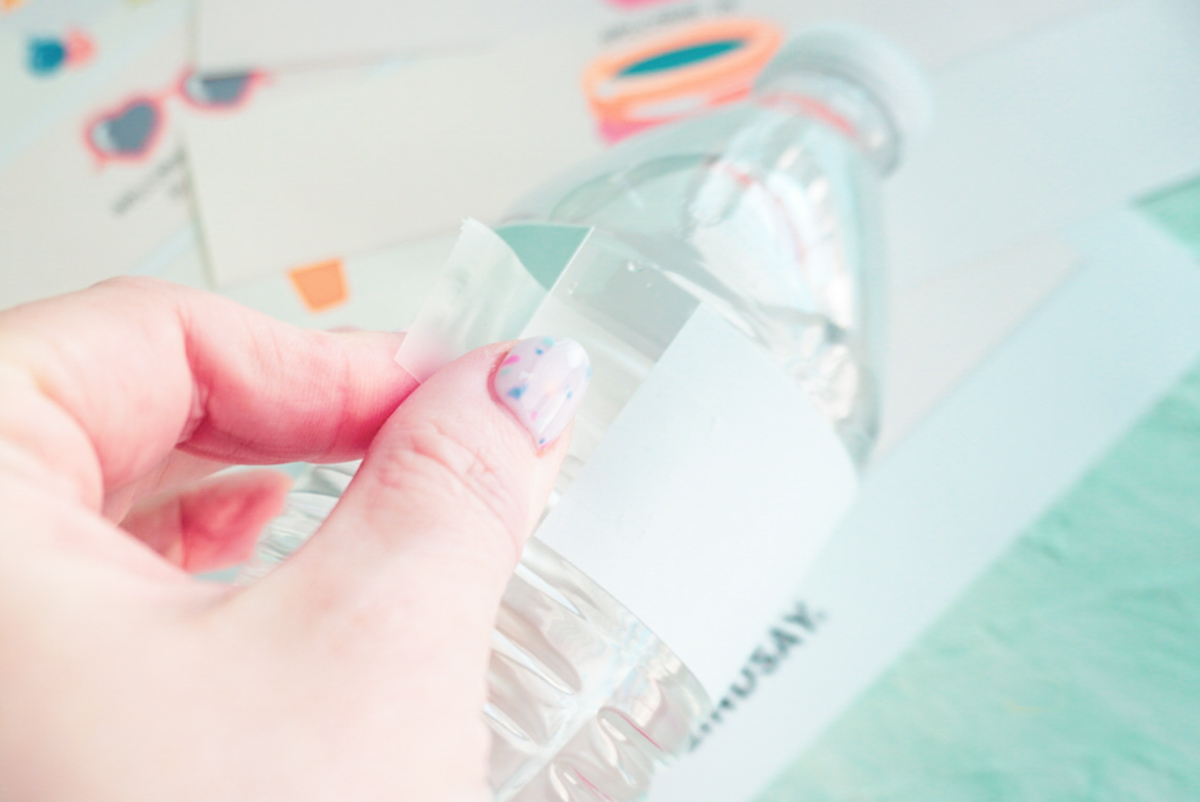 taping a free summer printable to a water bottle